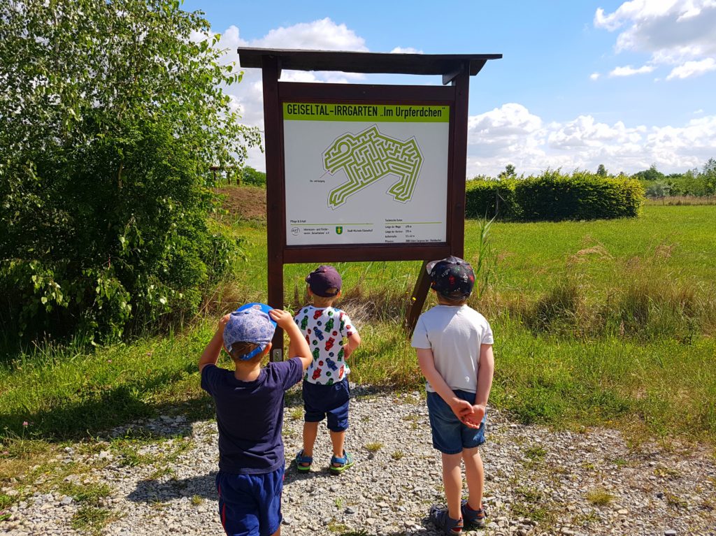 3 Jungs stehen vor der Infotafel am Irrgarten Urpferdchen