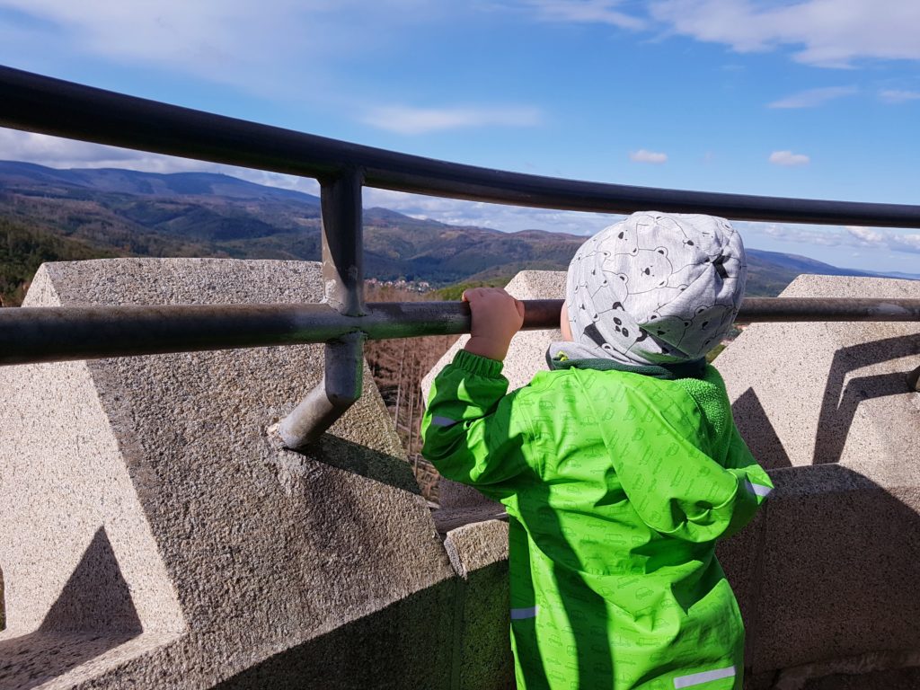 Kind genießt die Aussicht vom Bilsmarkturm auf dem Wernigeröder Märchenweg im Harz, Blick auf den Brocken