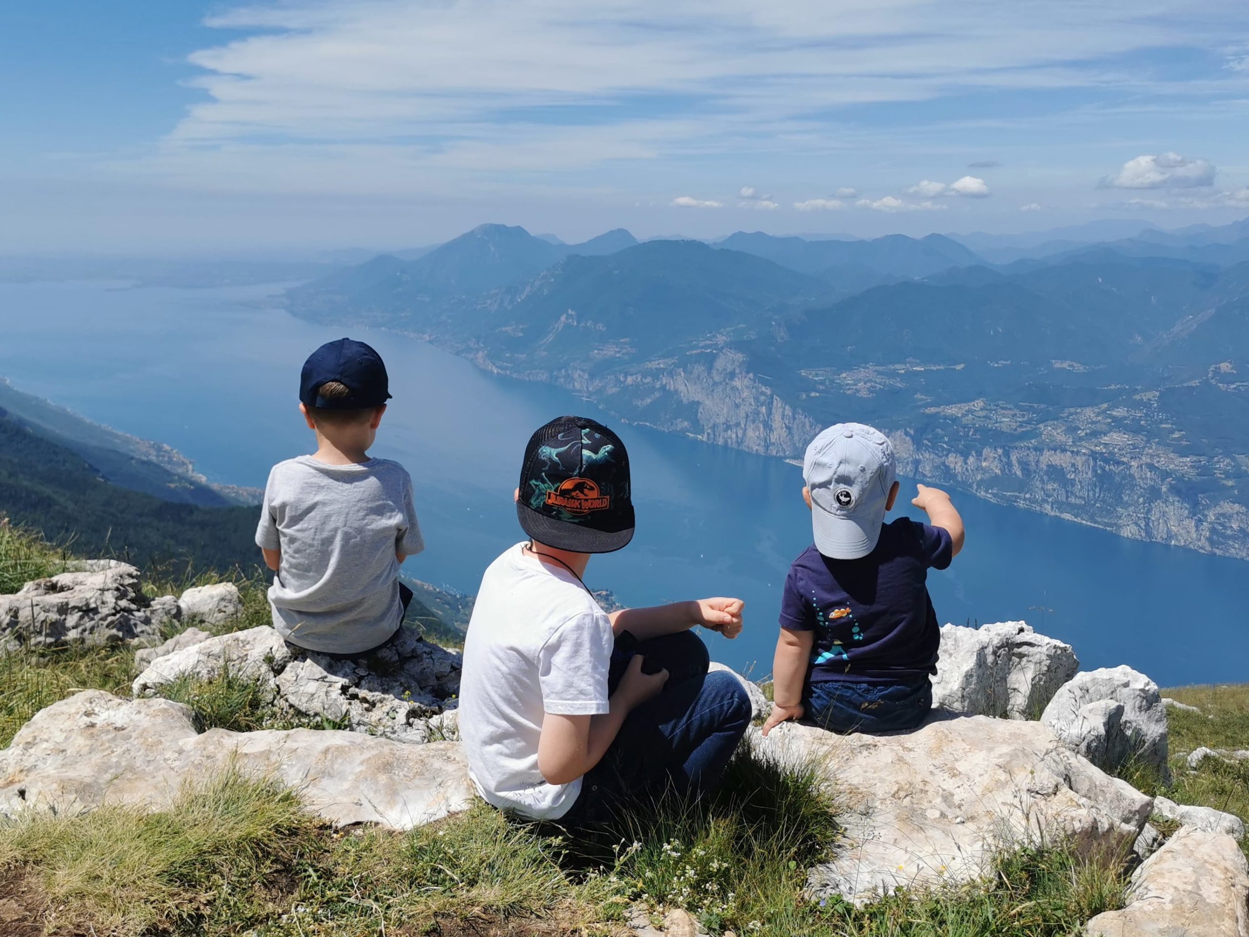die Kinder sitzen auf dem Monte Baldo und schauen auf den Gardasee